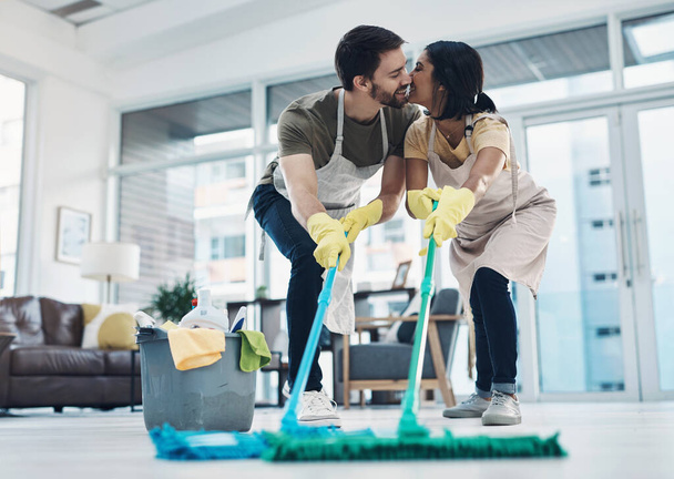決して洗い流さない唯一のものは、彼らの愛です。お気に入りの若いカップルが家で一緒に床を掃除し - 写真・画像