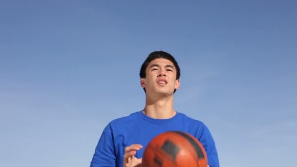 Teen shoots in basketball hoop - Filmati, video