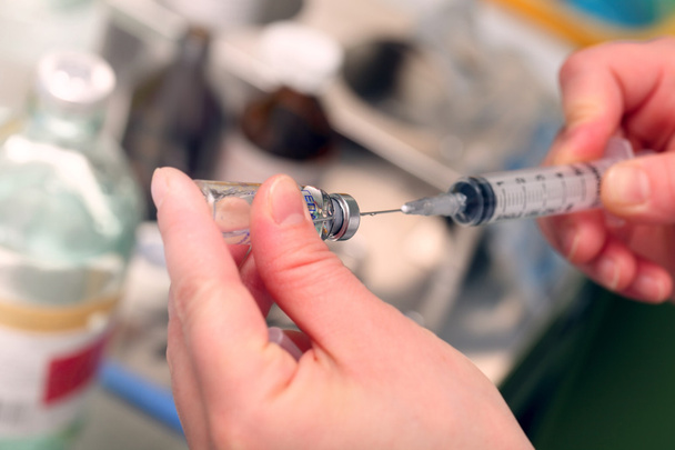Hospital nurse fills a syringe medication from a vial - Foto, imagen