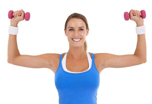 Toning those arms. Fit young woman smiling while using dumbbells against a white background - Foto, Imagem