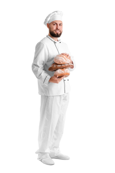 Male baker with loaves of fresh bread on white background - Fotoğraf, Görsel
