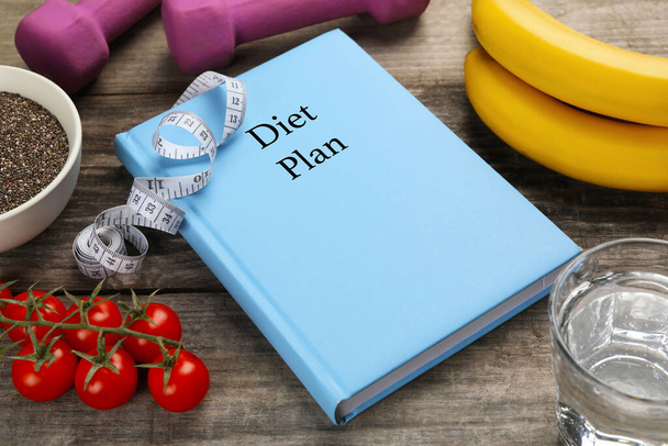 Weight loss concept. Notebook, fitness items and different products on wooden table - Foto, Imagem