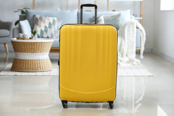 Yellow suitcase in living room - Fotoğraf, Görsel