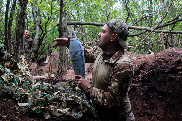 Soldado ucraniano del 28º Batallón de Artillería disparando un mortero de 120 mm contra un objetivo ruso en la línea cero en el bosque cerca de Bakhmut. Los ejércitos ruso y ucraniano chocan en el Donbass, la lucha es intensa y la batalla está furiosa. Con un - Foto, Imagen