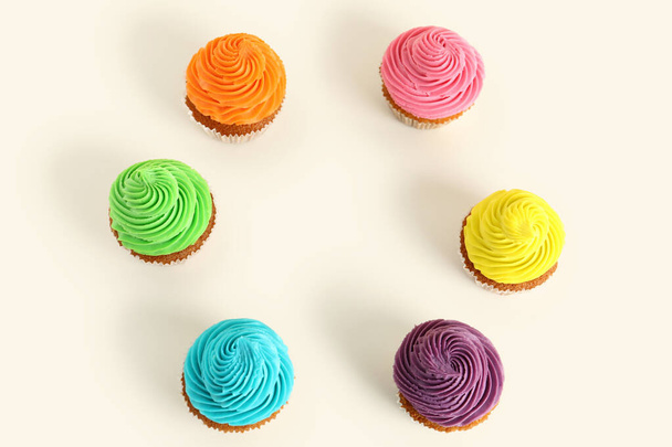 Cornice fatta di gustosi cupcake colorati su sfondo bianco - Foto, immagini