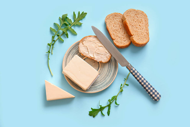 Тарелка и сэндвич с обработанным сыром на синем фоне - Фото, изображение