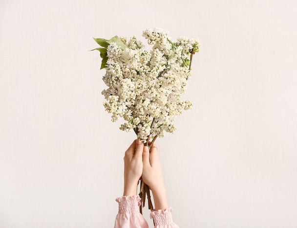 Manos femeninas con ramo de flores lila sobre fondo blanco - Foto, Imagen