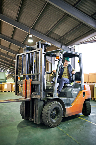 Rolling around the factory. a forklift driver in a warehouse - Photo, Image