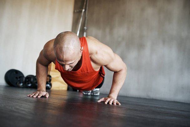Workout, strength and man doing push up for exercise, health commitment and training for muscle building growth. Fitness concentration, gym and strong male athlete doing floor endurance challenge. - Foto, Imagem