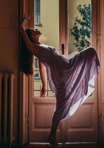 Woman meets morning near balcony. Relax time. Young woman standing near window. Erotic nightie. Passion and temptation. She happy dances - Foto, Bild