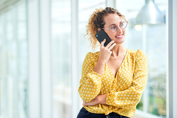 Cada llamada lleva a un nuevo contrato. una joven mujer de negocios usando un smartphone en una oficina moderna - Foto, Imagen
