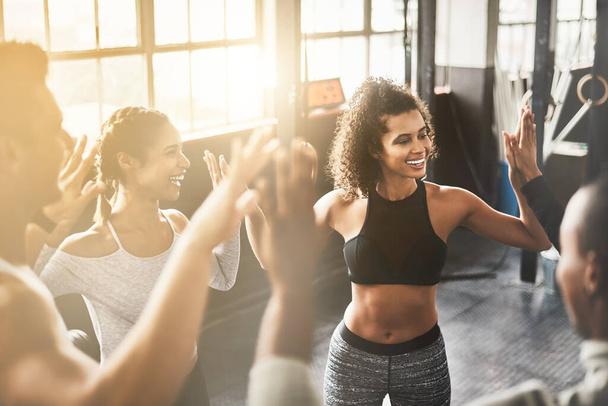 Laughing, high five and collaboration of people in gym for fitness, team building and solidarity. Teamwork, group of friends and celebration for sports targets, goal or support, success or trust - Foto, Imagen
