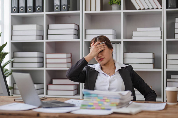 Fáradt ázsiai nő, stressz nő-ázsiai fiatal üzletasszony fejfájással az irodában, hányinger a munkahelyen, másolás hely.. - Fotó, kép