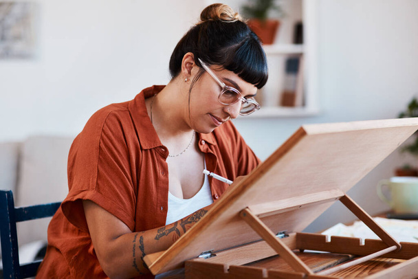 Do something creative each day. an artist sketching in a desk easel at home - Photo, Image