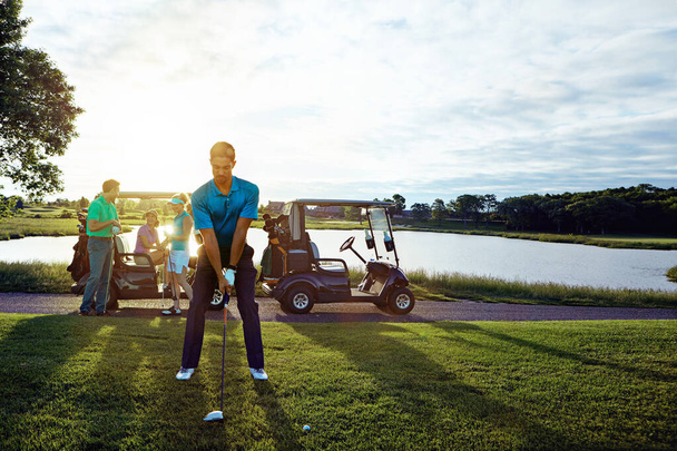 A golfrajongók azt csinálják, amihez a legjobban értenek. Egy férfi golfozik a barátaival. - Fotó, kép