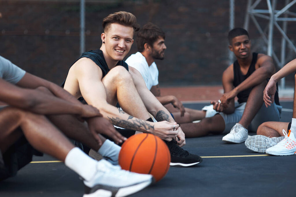 Prowadzenie zdrowego i satysfakcjonującego stylu życia. sportowy młody mężczyzna spędzający czas ze swoimi przyjaciółmi na boisku do koszykówki - Zdjęcie, obraz