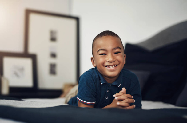 Everyone loves a happy kid. an adorable little boy lying on his bed at home - Φωτογραφία, εικόνα