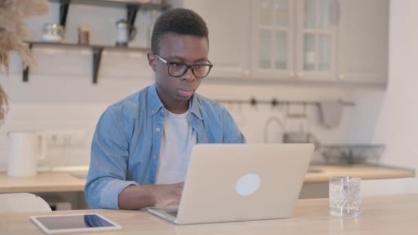 Giovane uomo africano tosse lavorando sul computer portatile - Filmati, video