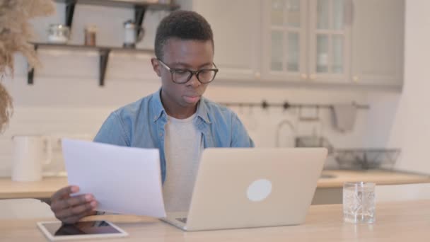 Dizüstü bilgisayarda ve belgelerde başarıyı kutlayan genç Afrikalı adam, - Video, Çekim