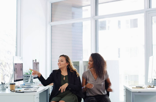 Quelle est votre opinion à ce sujet ? deux jeunes femmes d'affaires utilisant un ordinateur ensemble dans un bureau moderne - Photo, image