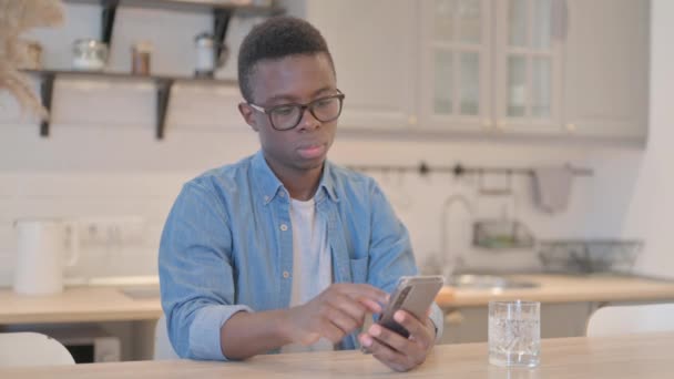 Giovane uomo africano utilizzando Smartphone al lavoro - Filmati, video