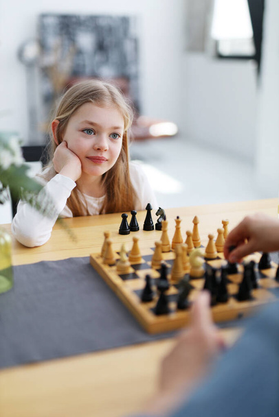 Concentrated little girl child playing chess, learning new strategies. - Foto, Imagen