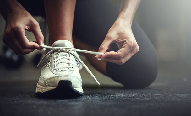 Woman tie shoe laces, hands and fitness with athlete in gym and sports with training for health. Closeup of runner sneakers, start workout in exercise studio with healthy and active female person. - Fotografie, Obrázek