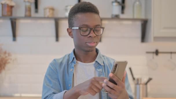 スマートフォンの損失によってショックを受けた若いアフリカ人男性の肖像 - 映像、動画