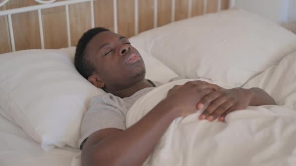 Hasta genç Afrikalı adam yatakta yatarken öksürüyor. - Video, Çekim
