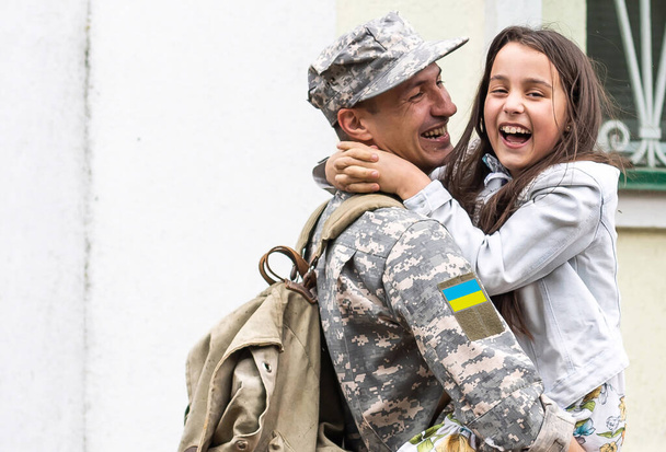 Padre con uniforme militar ucraniano y su hija. Reunión familiar. - Foto, imagen