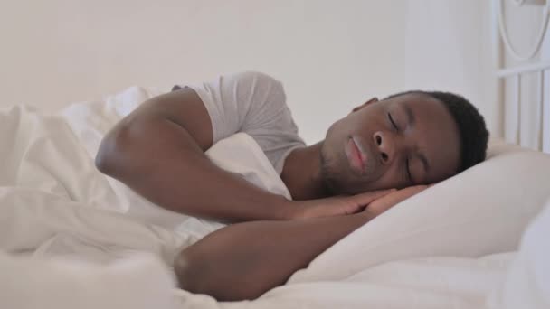 Zmęczony młody Afrykanin śpi w łóżku w domu - Materiał filmowy, wideo