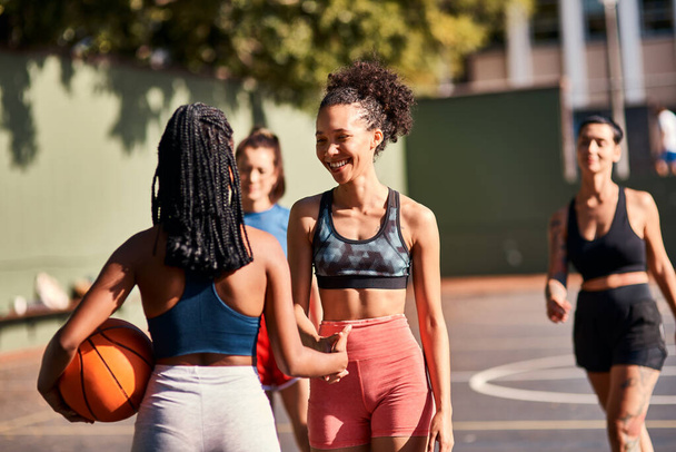 Well played. Low angle shot of a diverse group of friends huddled together after playing basketball during the day - Foto, Imagen