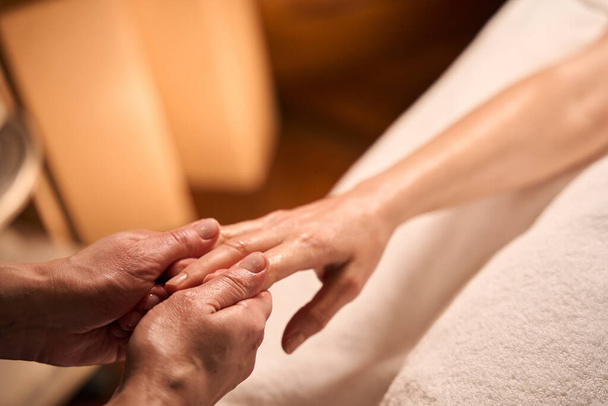 Przycięte zdjęcie masażysty rozciągającego palce dorosłej osoby - Zdjęcie, obraz
