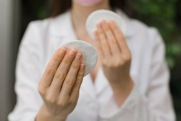 Image of hands holding cotton pads. Skin care concept. Mixed media. High quality photo - Foto, afbeelding