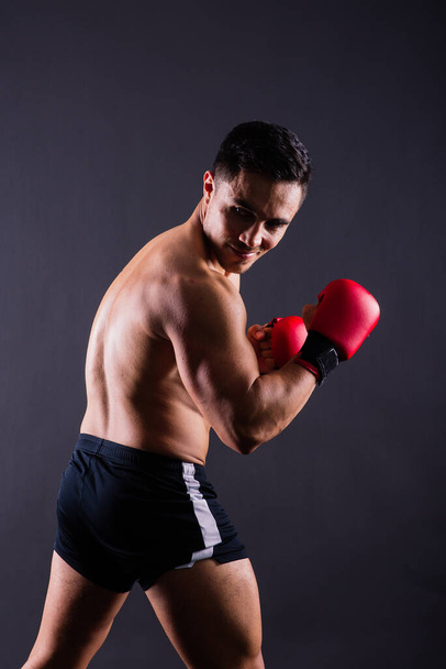 Atleta professionista pugile in guanti rossi isolato in studio. Sport, concetto di competizione. - Foto, immagini