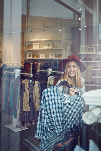 This will go with my new boots. a young woman shopping at a clothing store - Foto, Imagem