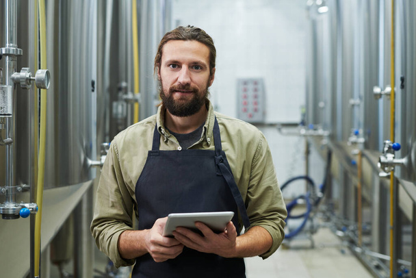 Porträt eines Bierfabrikarbeiters mit Tablet-Computer in der Hand - Foto, Bild