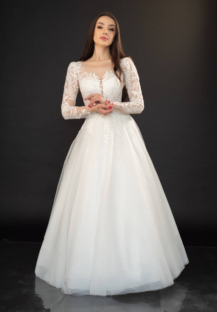 若い花嫁は白いスタジオの背景のウェディングドレス  - 写真・画像