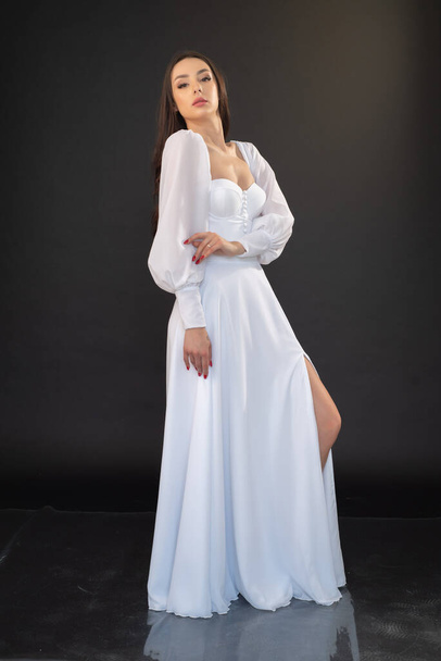 mooie jonge aziatische vrouw dragen witte bruiloft jurk op lichte achtergrond  - Foto, afbeelding