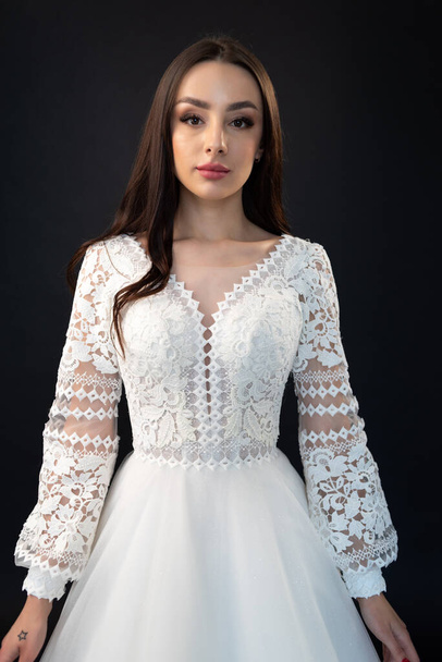 beautiful young bride in a white wedding dress on a light background  - Zdjęcie, obraz