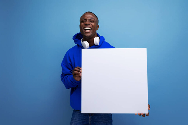 pozitív fiatal afrikai férfi egy mockup reklám a háttérben a másolás tér. - Fotó, kép