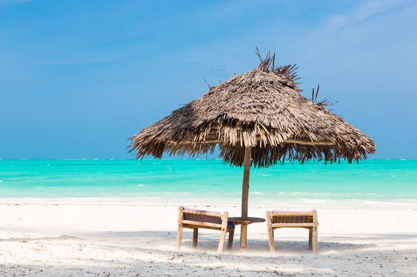 Duas cadeiras de convés e guarda-chuva na praia tropical
. - Foto, Imagem