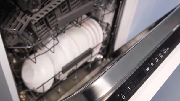 Bekapcsolom az automata mosogatógépet, tele piszkos edényekkel. Konyhai eszközök kiváló minőségű mosása. - Felvétel, videó