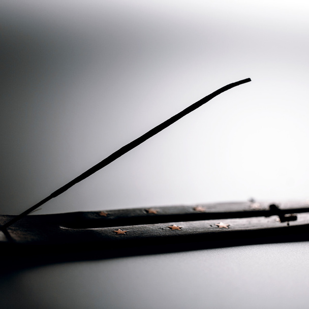Incense stick on a wooden support on a white background - Φωτογραφία, εικόνα