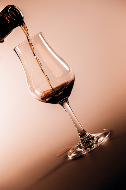 alkohol ital ömlött be a pohár, elszigetelt fehér background - Fotó, kép