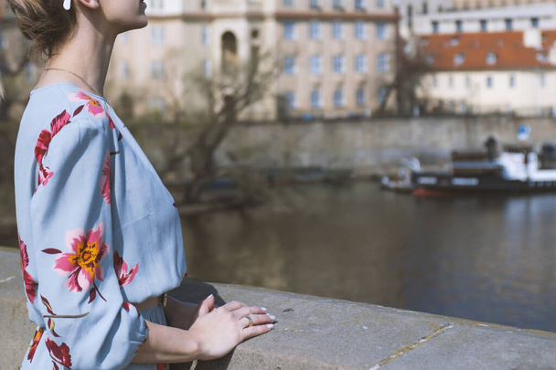 Young woman in a bright dress on the embankment of the Vltava River in Prague, Czech Republic - Φωτογραφία, εικόνα