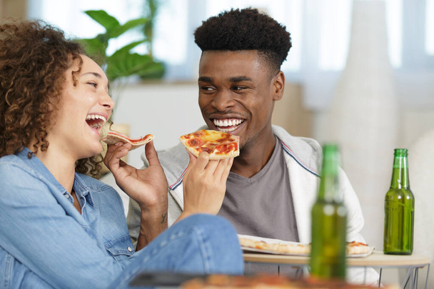 happy young couple preparing pizza in their home - Фото, изображение