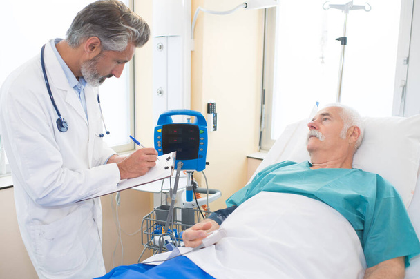 lékař se ptá na mužského zotavujícího se pacienta - Fotografie, Obrázek