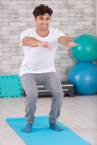 handsome young man doing exercise on top of a mat - Photo, image
