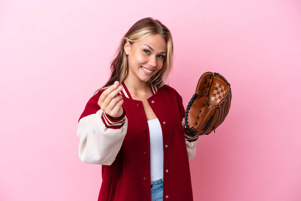 Player Russian woman with baseball glove isolated on pink background making money gesture - Foto, Bild